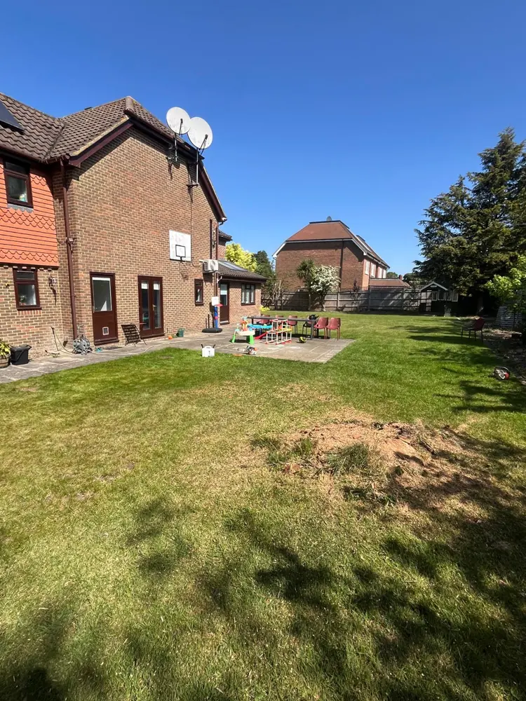 The same lawn cleared, the stump ground out and the ground levelled ready for turf